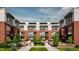 Elegant townhomes with brick accents, large windows, manicured green space, and outdoor seating in a courtyard setting at 11940 Citywalk Dr, Fishers, IN 46038