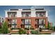 Beautiful three-story townhomes with brick facade, large windows, and manicured landscaping with inviting entryways at 11940 Citywalk Dr, Fishers, IN 46038