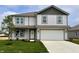 Charming two-story home with a well-manicured lawn, two-car garage, and light gray siding at 1204 Mcbride St, Greenfield, IN 46140