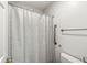 Bathroom featuring a patterned shower curtain, toilet, and towel bar, offering a functional design at 12388 Camberley Ln, Carmel, IN 46033