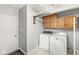 Convenient laundry room features washer, dryer, storage cabinets, and drying rack at 12388 Camberley Ln, Carmel, IN 46033
