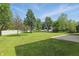 Expansive backyard featuring a lush lawn, mature trees, and a pristine white fence at 12409 Dellfield W Blvd, Carmel, IN 46033