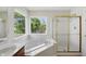 Bright bathroom featuring a soaking tub with jets and a glass-enclosed shower at 12409 Dellfield W Blvd, Carmel, IN 46033