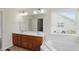 Bathroom featuring double sink vanity, soaking tub, and natural light at 12409 Dellfield W Blvd, Carmel, IN 46033