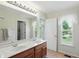 Bathroom featuring double sink vanity, natural light and tiled floors at 12409 Dellfield W Blvd, Carmel, IN 46033