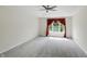 Spacious carpeted bedroom with large window and decorative red valance, offering ample natural light at 12409 Dellfield W Blvd, Carmel, IN 46033