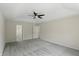 Bright, carpeted bedroom with tray ceilings, ceiling fan, and doorway to an ensuite bathroom at 12409 Dellfield W Blvd, Carmel, IN 46033