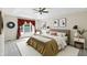 Bright bedroom featuring tray ceilings, stylish decor, and natural light from a large window at 12409 Dellfield W Blvd, Carmel, IN 46033