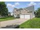 Charming two-story brick home with a three-car garage and well-manicured lawn at 12409 Dellfield W Blvd, Carmel, IN 46033