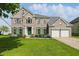 Charming two-story brick home with well-manicured lawn, attached garage, and eye-catching green shutters at 12409 Dellfield W Blvd, Carmel, IN 46033