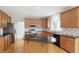 Modern kitchen with stainless appliances, granite counters, wood cabinets, and wood floors at 12409 Dellfield W Blvd, Carmel, IN 46033