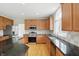 Beautiful kitchen features granite counters, custom cabinetry, wood floors, and stainless appliances at 12409 Dellfield W Blvd, Carmel, IN 46033