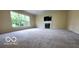 Large carpeted living room with fireplace and large windows offering views at 12409 Dellfield W Blvd, Carmel, IN 46033