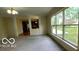 Open-concept living room with large windows and view into the kitchen at 12409 Dellfield W Blvd, Carmel, IN 46033