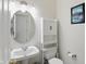 Compact powder room includes pedestal sink, decorative mirror and convenient cabinet with storage at 12409 Dellfield W Blvd, Carmel, IN 46033