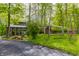 Secluded home exterior surrounded by mature trees and lush greenery, showcasing unique architectural design at 12469 Springmill Rd, Carmel, IN 46032
