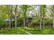 Home exterior framed by mature trees, featuring a stone facade and a welcoming entrance at 12469 Springmill Rd, Carmel, IN 46032