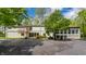 Exterior view featuring the home's classic facade, surrounded by mature trees, a well-kept lawn, and a spacious driveway at 12469 Springmill Rd, Carmel, IN 46032