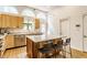 Bright kitchen with stainless steel appliances, an island with seating, and natural wood cabinetry at 12469 Springmill Rd, Carmel, IN 46032