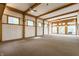 Expansive living room showcasing exposed wood beams, natural light from numerous windows, and neutral carpeting at 12469 Springmill Rd, Carmel, IN 46032