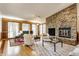 Cozy living room featuring a stone fireplace, hardwood floors, and comfortable seating creating an inviting gathering space at 12469 Springmill Rd, Carmel, IN 46032
