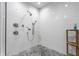 Spa-like shower with multiple shower heads, pebble floor, and bright tile at 12469 Springmill Rd, Carmel, IN 46032
