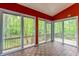 Sunroom featuring wall-to-wall sliding glass doors with views of the surrounding landscape and wood-patterned floors at 12469 Springmill Rd, Carmel, IN 46032