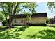 Well-maintained home with lush green lawn and mature tree providing ample shade at 1310 Kings Cove Ct, Indianapolis, IN 46260
