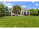 Spacious backyard with mature trees, lush green lawn, and a charming patio and screened porch, ideal for relaxation at 14094 Pecos Ct, Carmel, IN 46033