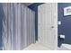 Cozy bathroom featuring a blue striped shower curtain and a white tiled floor at 14094 Pecos Ct, Carmel, IN 46033