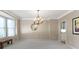 Elegant dining room featuring a decorative chandelier, large window, and neutral walls at 14094 Pecos Ct, Carmel, IN 46033