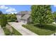 Three-car garage home featuring a well manicured lawn with mature trees and landscaping at 14094 Pecos Ct, Carmel, IN 46033