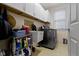 Functional laundry room provides ample storage, built-in sink, and modern washer and dryer at 14094 Pecos Ct, Carmel, IN 46033