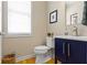 Chic powder room featuring a modern vanity with blue cabinets, hardwood floors, and neutral colored walls at 14094 Pecos Ct, Carmel, IN 46033