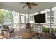 Bright screened porch with a cozy seating arrangement and outdoor TV, offering a relaxed view of the backyard at 14094 Pecos Ct, Carmel, IN 46033