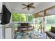 Cozy screened porch featuring a comfortable sofa, tropical rug, and a ceiling fan for relaxed outdoor living at 14094 Pecos Ct, Carmel, IN 46033