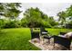 Outdoor seating on a wood patio features lush green grass and mature trees making for a serene and private backyard retreat at 1431 N Bolton Ave, Indianapolis, IN 46219