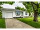 Quaint home with an attached garage, complemented by a green lawn and sidewalk at 1431 N Bolton Ave, Indianapolis, IN 46219