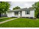 Inviting home with green lawn, complemented by a quaint front facade and attached garage at 1431 N Bolton Ave, Indianapolis, IN 46219