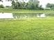 Scenic view of a calm pond with lush green surroundings, creating a peaceful and natural setting at 160 Rambling Rd, Greenfield, IN 46140