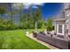 A spacious backyard with well-manicured lawn, patio seating, and mature trees offering shade at 1701 Summerwood Blvd, Greenfield, IN 46140