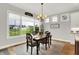 Bright dining area with large windows offering a golf course view and a stylish chandelier above the table at 20010 Prescott Pl, Westfield, IN 46074