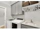 Well-lit laundry room features gray cabinetry, modern washer and dryer, and a functional sink area at 20010 Prescott Pl, Westfield, IN 46074