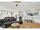Open-concept living room with hardwood floors, modern decor, and seamless flow into a white-cabinet kitchen at 20010 Prescott Pl, Westfield, IN 46074