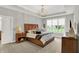 Comfortable bedroom with a wooden headboard, tray ceiling, chandelier, and plush carpet at 20010 Prescott Pl, Westfield, IN 46074