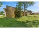 View of a fenced backyard with mature trees and lush lawn, with a patio area and firepit at 205 Canaan Ct, Mooresville, IN 46158