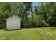 Backyard featuring a storage shed, fire pit, and brick-lined square feature in a spacious lawn at 205 Canaan Ct, Mooresville, IN 46158