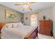 Comfortable bedroom featuring a ceiling fan, framed art, and a dresser with decorative items at 205 Canaan Ct, Mooresville, IN 46158