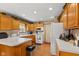 Charming kitchen with wood cabinets, white appliances, and a breakfast bar creating a warm atmosphere at 205 Canaan Ct, Mooresville, IN 46158