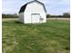 Simple white barn on a grassy field, offering classic country appeal and versatile storage or workspace options at 21749 Oak Ridge Rd, Sheridan, IN 46069